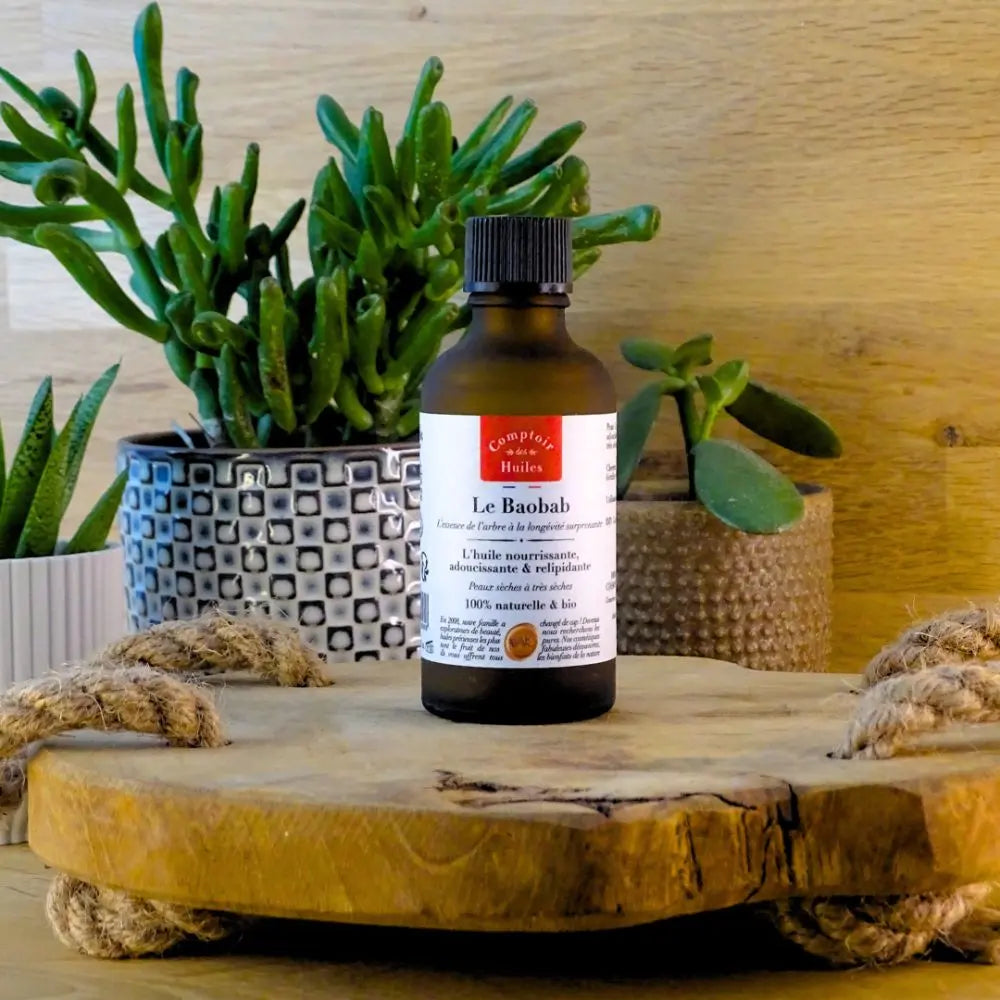 Une Huile de Baobab BIO 50ml Comptoir des Huiles posée sur un rondin en bois