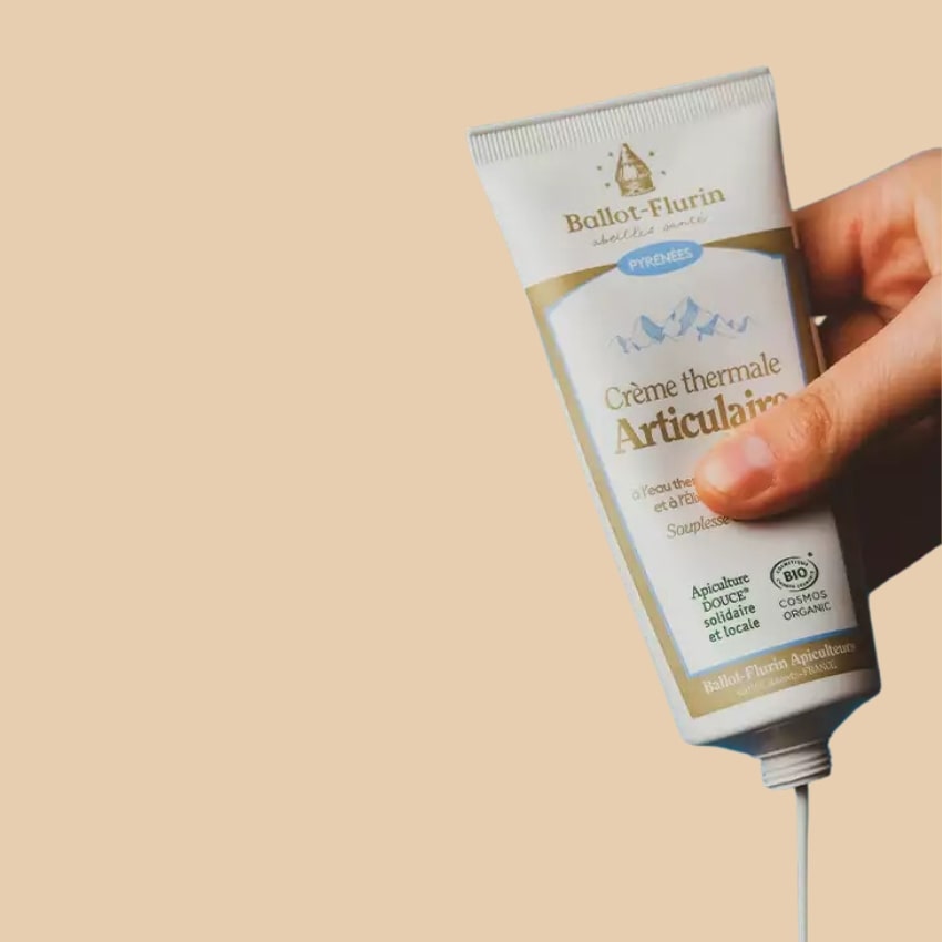 Une personne versant de la Crème thermale Articulaire Bio  Ballot-Flurin