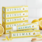 Un tube de Dentifrice Meswak ayurvédique goût citron posé à côté d'une rondelle de citron