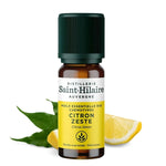 Un flacon de 10ml d'huile essentielle citron zeste de la distillerie Saint-Hilaire accompagné de citron en arrière plan.