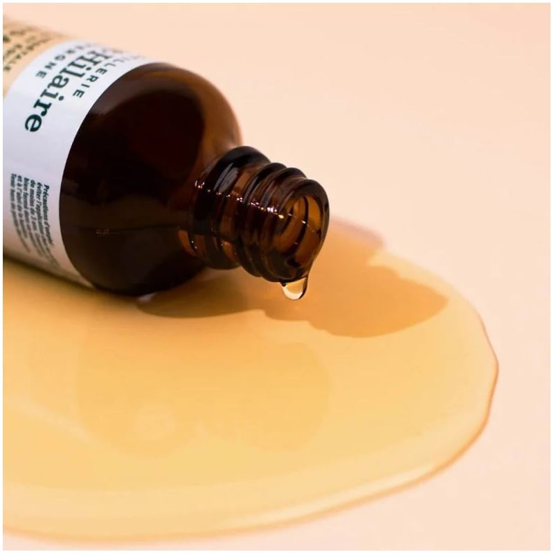 Un flacon d'Huile Végétale d'Abricot Bio Saint-Hilaire renversé, avec de l'huile tout autour