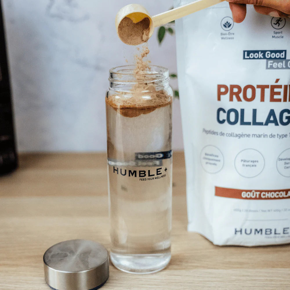 Une gourde remplie d'eau avec une cuillère doseuse versant de la protéine au chocolat