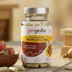 Une boite de Propolis ULTRA Défenses Immunitaires de 120 gélules Propolia, posé à côté d'un bol rempli de propolis