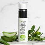 Sérum Dermoline Hydric de LT Labo sur un plateau en marbre, avec des feuilles d'aloe vera, des brins de romarin et des éclaboussures d'eau, mettant en avant ses ingrédients naturels et bio.