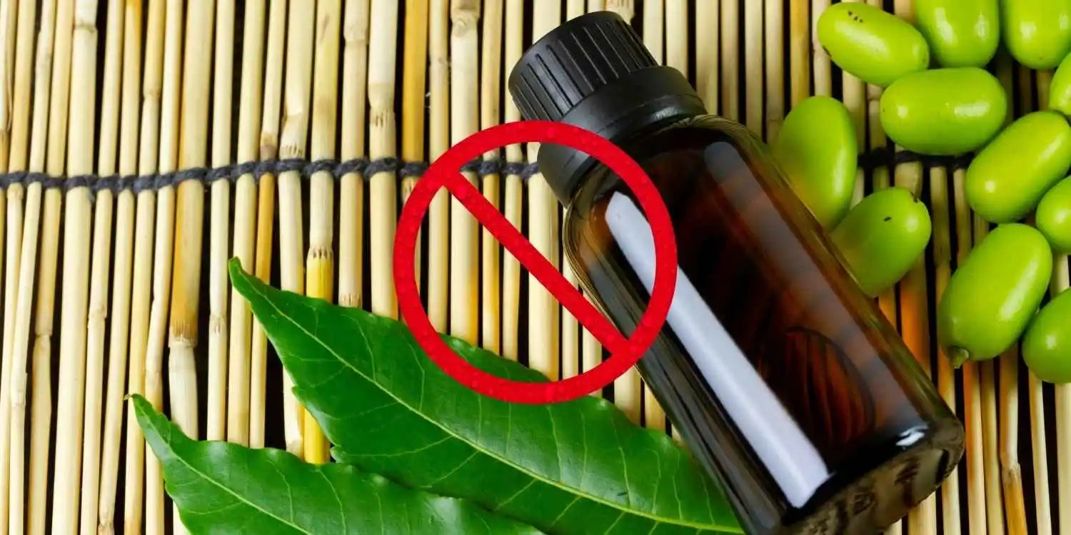 Un flacon d'huile de neem posé à côté des graines, avec un logo interdit