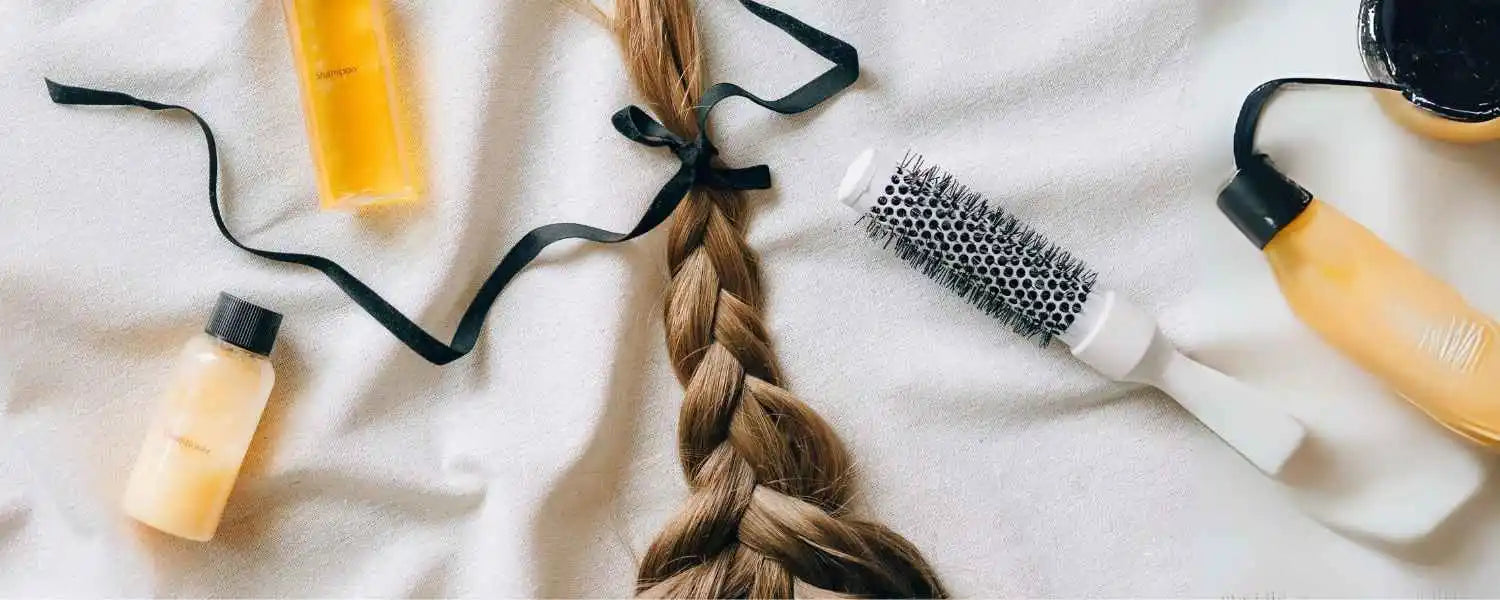 Un shampooing posé à côté d’une tresse de cheveux coiffée