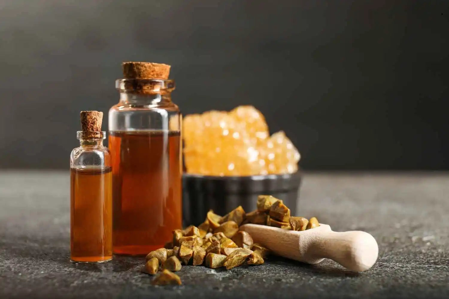 Un bol rempli de propolis blanche posé sur une table à côté de deux flacons de miel