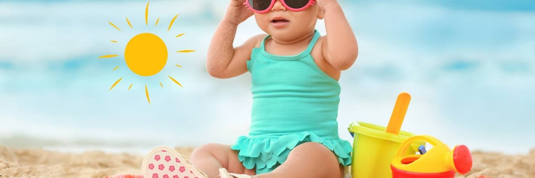 Un bébé posé sur le sable sur une plage ensoleillée, illustrant les apports en vitamine D
