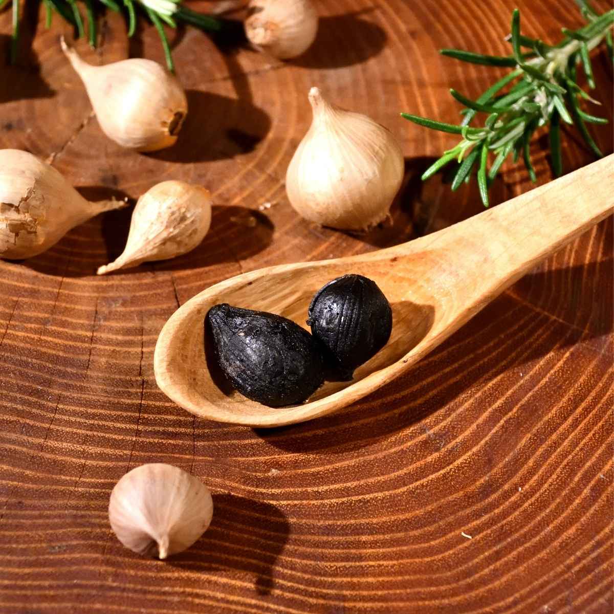 De l'ail noir disposé dans une cuillère en bois