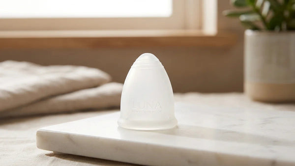Cup menstruelle en silicone médical sur surface marbre, guide complet choix 2024