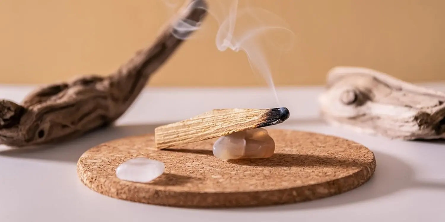 Un baton de palo santo en train de brûler et diffuser de la fumée dans une pièce