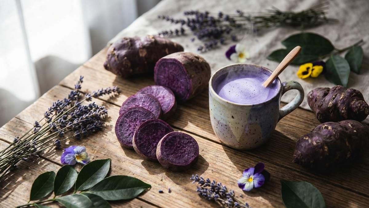 Patate douce violette tranchée avec boisson ube et tubercules entiers en flat-lay