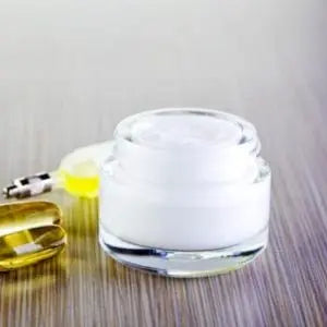 Pot de crème anti-âge ouvert à côté d'un flacon de sérum
