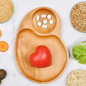 Cœur rouge dans une assiette en bois entourée de gélules et de céréales