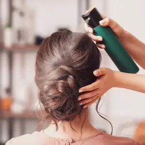 Femme se faisant coiffer un chignon avec un spray coiffant
