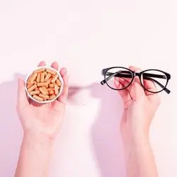 Photos de compléments alimentaires tenus dans la main gauche, et une paire de lunette tenue dans la main droite