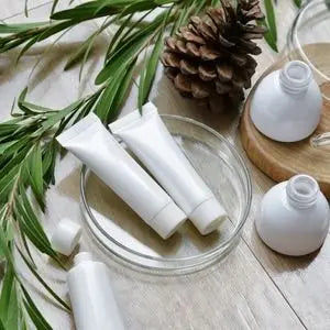 Tubes et flacons de cosmétiques naturels blancs entourés de branches d'olivier et d'une pomme de pin