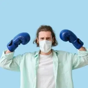 Homme portant un masque et des gants de boxe, prêt à défendre son immunité