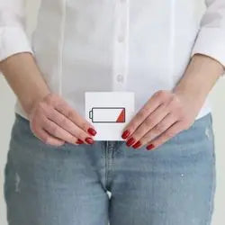 Femme tenant devant elle une carte illustrée d'une batterie presque vide