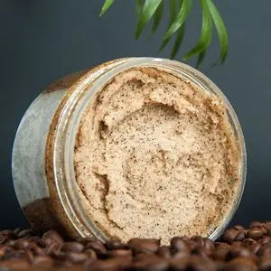 Pot de gommage au café à la texture granuleuse posé sur des grains de café