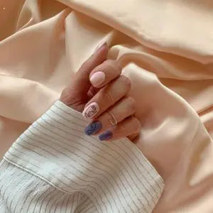 Main aux ongles manucurés posée sur un tissu en lin beige