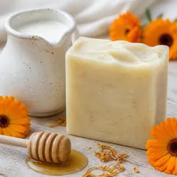Savon au lait de chèvre avec un pichet de lait, du miel et des fleurs de souci