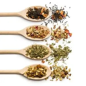 Cuillères en bois remplies de différentes variétés de thés et de tisanes