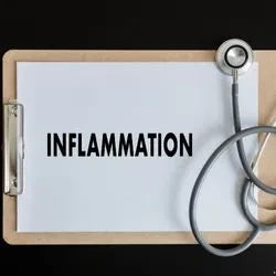 Un tableau blanc avec écrit dessus le mot "inflammation" et un stéthoscope posé à côté