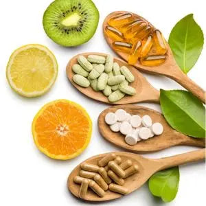 Agrumes, kiwi et gélules de vitamines dans des cuillères en bois