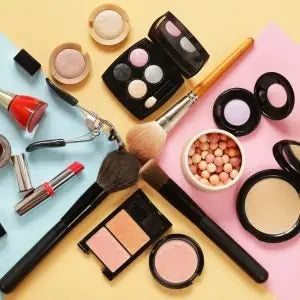Palettes d'ombres à paupières, pinceaux et produits de maquillage sur fond coloré