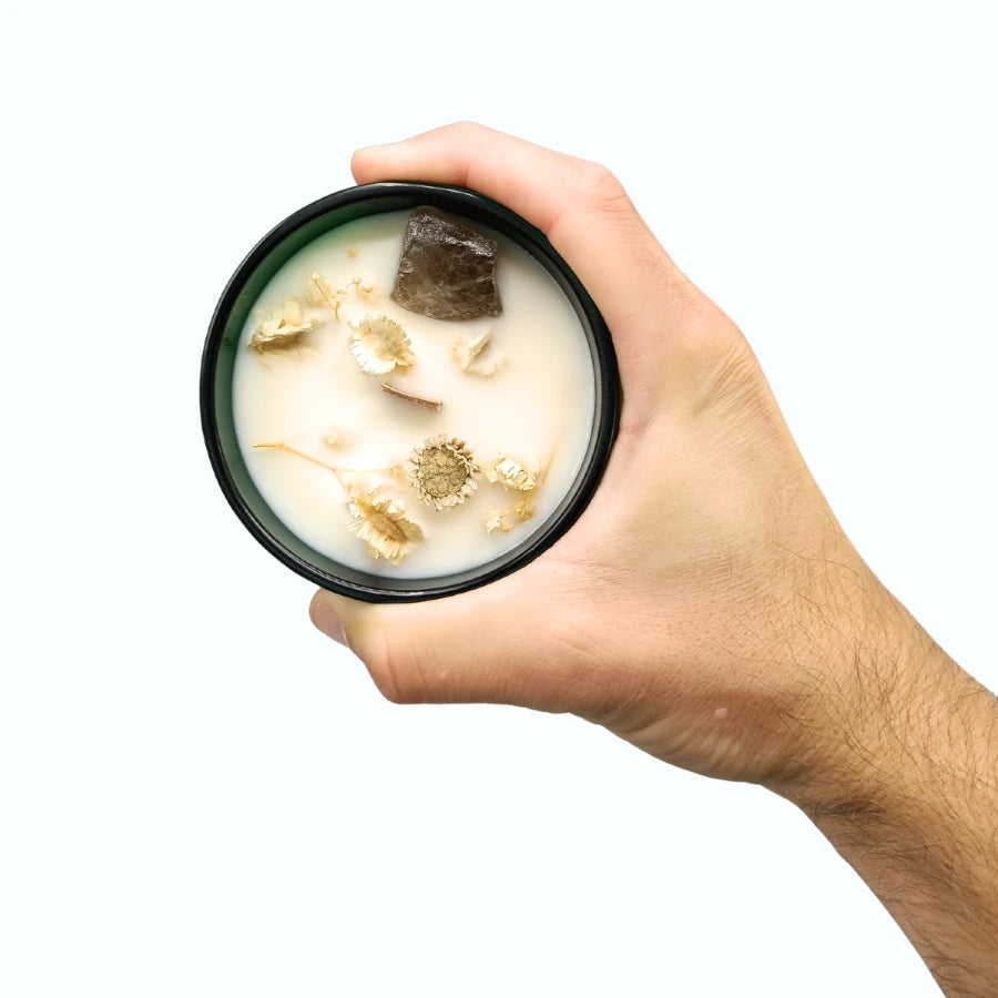 Une bougie magique jasmin de 330g de la marque hope hare tenue dans une main.