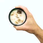 Une bougie magique jasmin de 330g de la marque hope hare tenue dans une main.