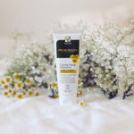 Un tube de de Crème Pieds Réparatrice au Miel de Manuka Bio de 75ml de Comptoirs et compagnies posé sur un drap blanc