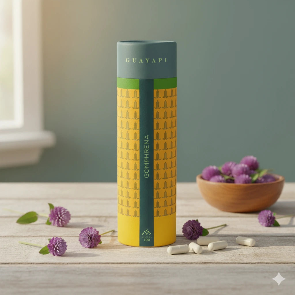 Flacon jaune et vert de Gomphrena, entouré de gélules blanches et de fleurs mauves sur une table en bois.