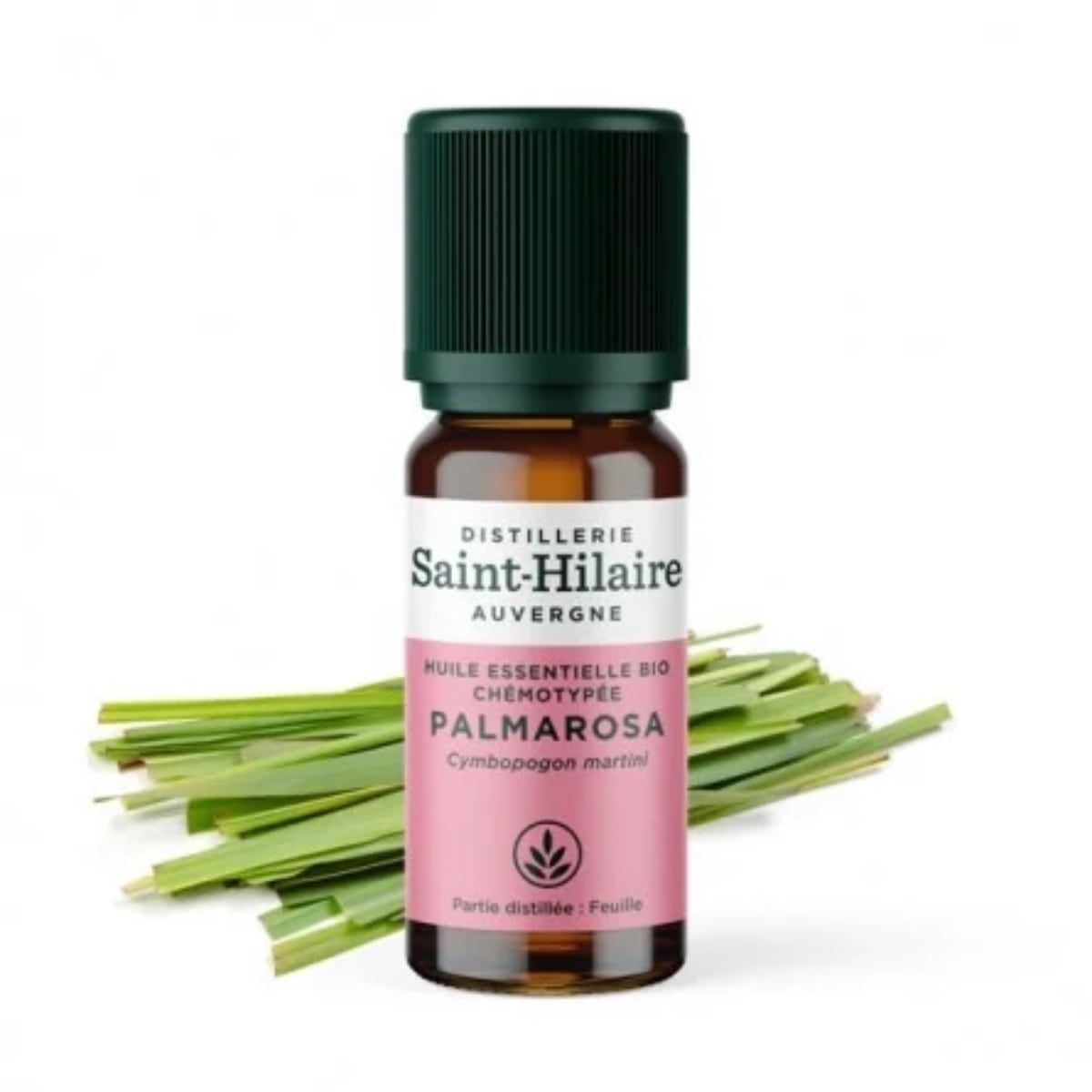 Un flacon de 10ml d'huile essentielle de Palmarosa de la distillerie Saint-Hilare accompagné de plantes de palmarosa en arrière plan. 