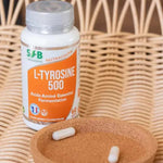 Une boite de L-Tyrosine de 60 gélules de la marque SFB Laboratoires avec ds gélules dans un couvercle en liège