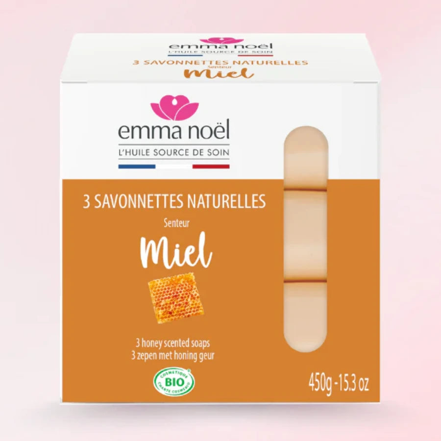 Savonnettes miel bio de 3 x 150 g de la marque EMMA NOËL sur fond rose.