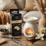 Cire parfumé à la vanille entrain de bruler dans u bruleur scentships et posé sur une table en bois. Des gousses de vanille sont également présentes.