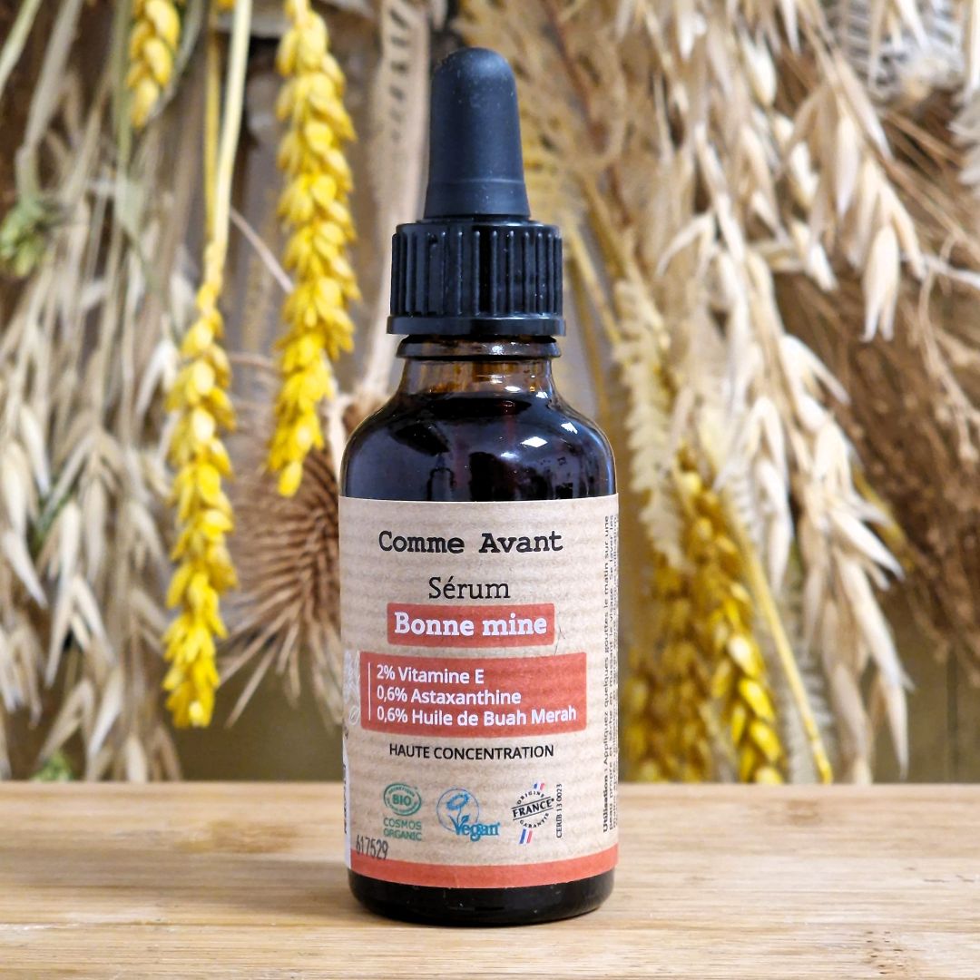 Un Sérum visage bonne mine en flacon de 30 ml posé sur une table en bois
