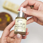 Un flacon d'Absolu Pur'Immortelle certifié bio tenu en main
