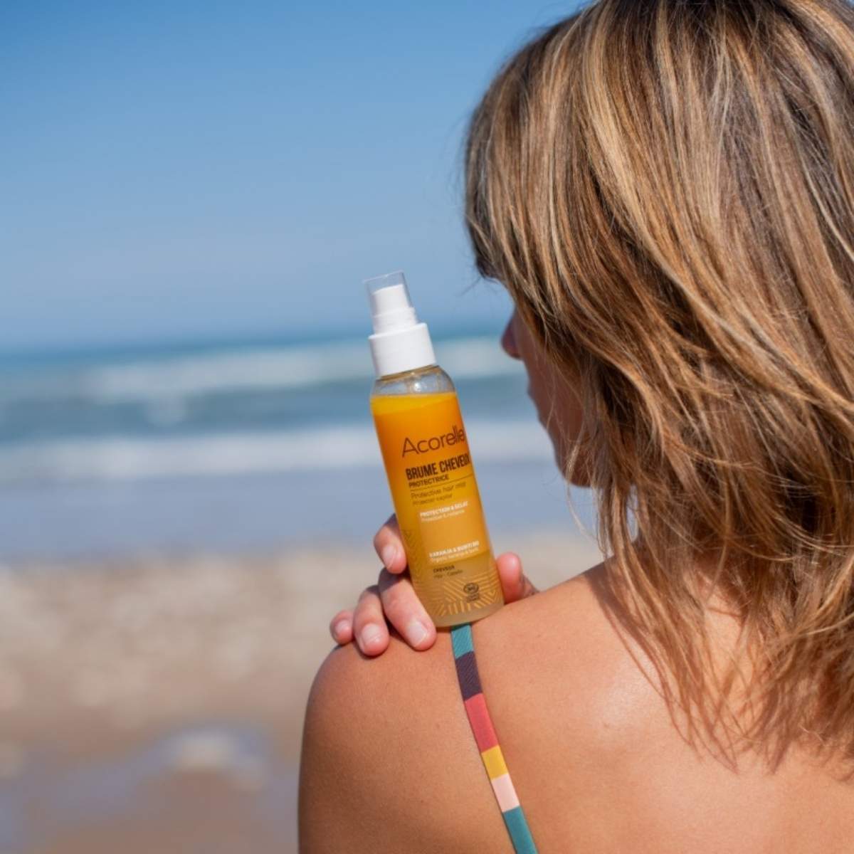 Brume pour les cheveux posés sur les épaules d'une femme.