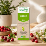 Airelle Bio HerbalGem 30ml entourée de cranberries frais et feuilles vertes sur bois naturel