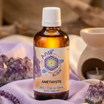Flacon Ansil Améthyste élixir cristal 30ml entouré d'améthystes et textiles lavande