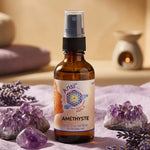 Huile de cristal Améthyste Ansil 50ml en flacon ambré sur tissu lavande avec cristaux