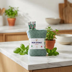 Éponges lavables écologiques Anotherway vertes et bleues sur plan de travail cuisine blanc