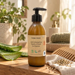 Après-shampoing à l'huile de chanvre 200 ml Comme Avant, flacon ambré à pompe sur étagère en bois entouré d'aloe vera