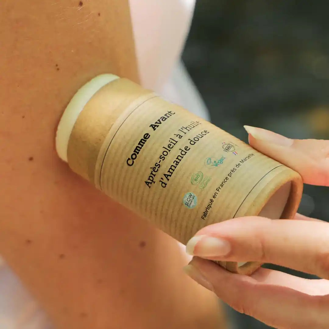 Un après-soleil à l’huile d’amande douce de 70 g de la marque Comme Avant en train d'être appliqué sur la peau