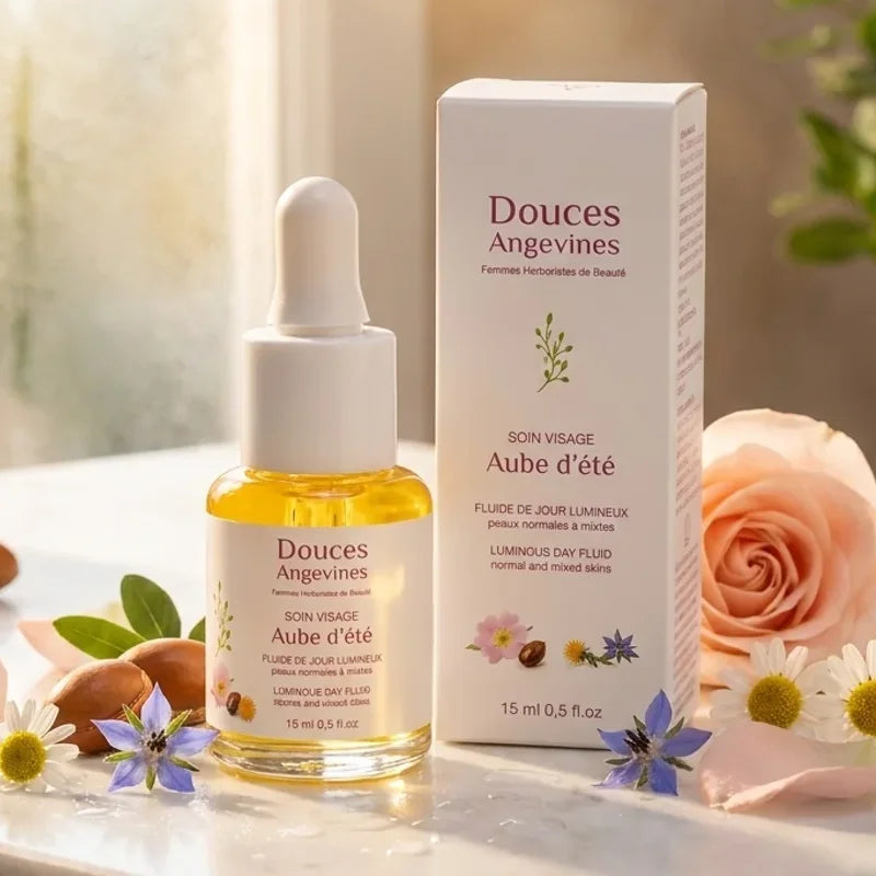 Flacon Aube d'été soin visage jour sur vanité marbre avec fleurs botaniques et lumière naturelle
