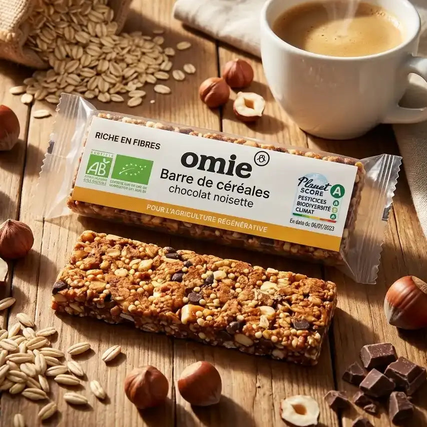 Barre de céréales chocolat noisette bio Omie 25g avec noisettes et café sur table bois