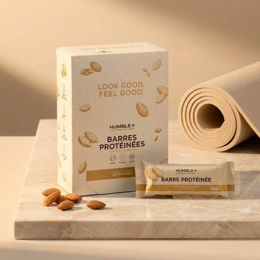 Barre protéinée amande Humble+ avec emballage crème et amandes sur surface marbre